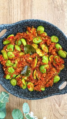 brussel sprouts with sauce in a blue bowl on a wooden table