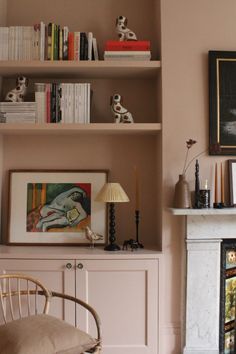 a living room filled with furniture and a fire place next to a wall mounted book shelf