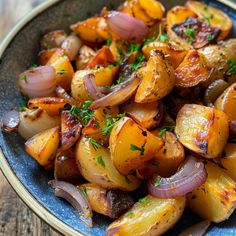 a blue plate topped with potatoes and onions