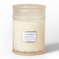 a candle that is white and has a label on the front, with an ornate design