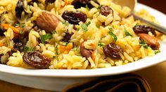 a white plate topped with rice and raisins