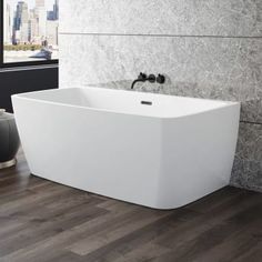 a large white bath tub sitting on top of a wooden floor next to a window