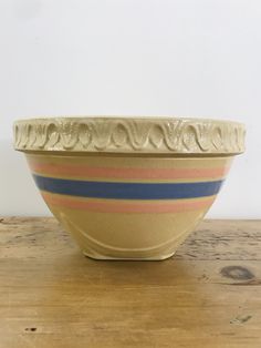 a striped bowl sitting on top of a wooden table