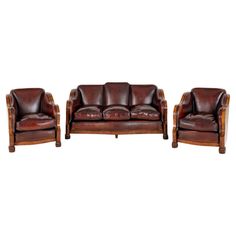 a set of three leather couches and two chairs with wood frames on each side