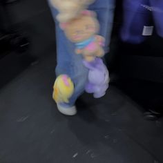 a blurry photo of someone walking with stuffed animals on their back legs and feet