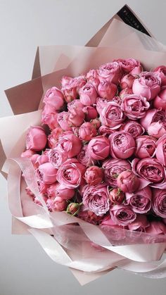 a bouquet of pink roses is wrapped in paper