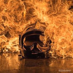 a motorcycle helmet on fire with flames in the background