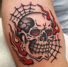 a skull and web tattoo on the leg