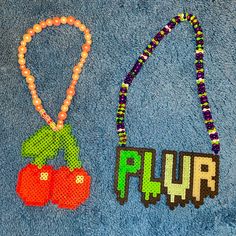 two beaded necklaces on a blue towel with the word flur spelled out