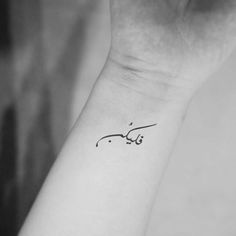 a black and white photo of a woman's wrist tattoo