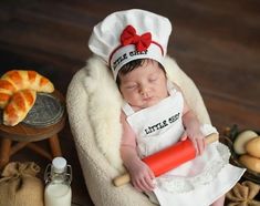 a baby wearing a chef's hat and holding a rolling pin