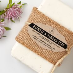 a bar of soap sitting on top of a table next to flowers