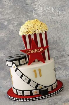 a cake decorated with popcorn, film strips and a star for the number one on top