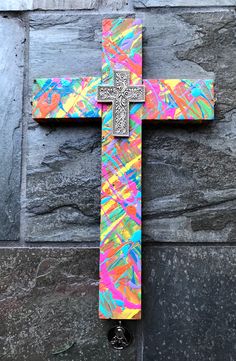 the cross is painted with multicolored paint and has a black shoe underneath it