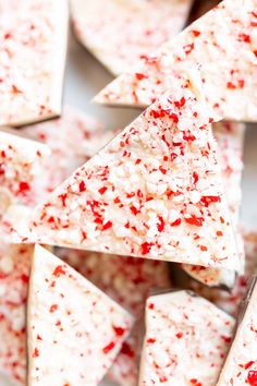 white chocolate with red sprinkles on a plate next to some other pieces