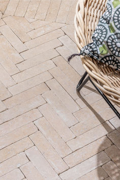 a wicker chair sitting on top of a brick floor