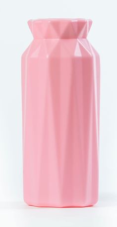 a pink vase sitting on top of a white table