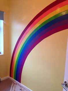 a bedroom with a rainbow painted on the wall