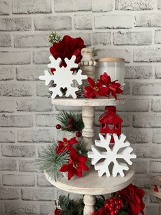 a three tiered christmas tree with red and white decorations on it, including snowflakes