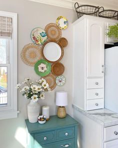 a kitchen with plates and flowers on the wall