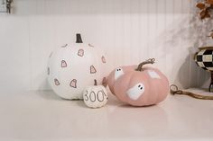 three painted pumpkins sitting on top of a counter