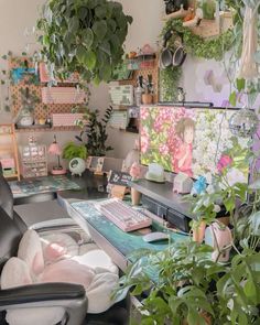 a home office with plants and pictures on the wall