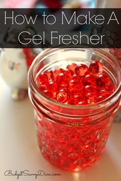 a jar filled with red beads sitting on top of a table