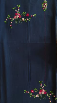 an embroidered blue cloth with red flowers and green leaves