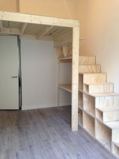 an empty room with wooden shelves and stairs