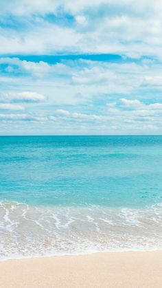 the surfboard is laying on the beach near the water's edge as it sits in the sand