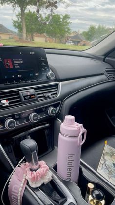 the interior of a car with an electronic device and cup holder on it's dash board