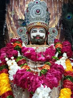 the statue is decorated with flowers and feathers