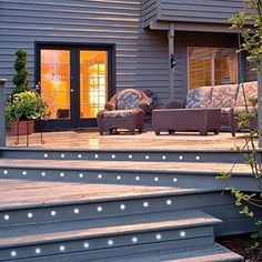 an outdoor deck with lights on the steps