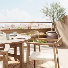 a table and chairs on a balcony overlooking the city