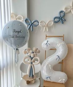 balloons and decorations are arranged in the corner of a room with a balloon shaped like a number