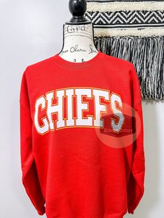 Chiefs Crewneck Sweatshirt! Winter Collegiate Crew Neck T-shirt, Collegiate Crew Neck T-shirt For Winter, Crew Neck T-shirt For Game Day In Fall, School Spirit Graphic Print Top For Winter, Varsity T-shirt For Winter, Varsity Style Pre-shrunk Crew Top, Collegiate Crew Top For Winter, Winter Game Day Relaxed Fit Tops, Team Spirit Crew Neck Top With Ribbed Cuffs