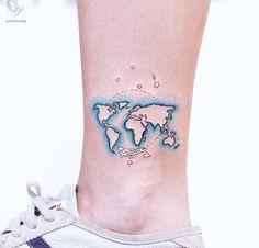 a small world map tattoo on the ankle