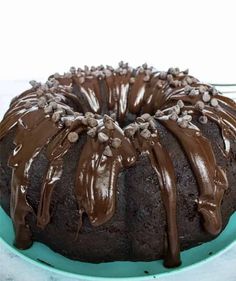 a bundt cake with chocolate frosting and sprinkles on a blue plate