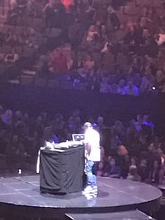 a man standing on top of a stage in front of an audience