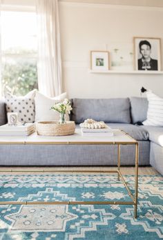 a living room with a couch, coffee table and pictures on the wall