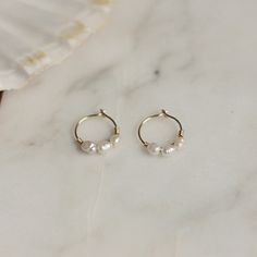 "Small hoop earrings with tiny pearl bead, each bead is different. Choose your style, 1, 2, or 3 pearls. Sold as 1 pair Material pearl: Real sweet water pearl, measurement pearl 4x2mm Diameter hoop: 10mm/0,39\" (small/average ears) or 12mm/0.47\" (bigger ears) Please measure the distance from the edge of your earlobes to the pierced hole, to choose the right hoop size! The model wears 10mm on the photo. Thickness hoop: 22 gauge/0.6mm These hoops are small and can be difficult to put on. When put Affordable Dainty Round Pearl Earrings, Affordable Minimalist Hypoallergenic Pearl Earrings, Cheap Small Hoop Wedding Jewelry, Medium Hoop Earrings With Pearl, Cheap Gold Minimalist Pearl Earrings, Cheap Minimalist Pearl Earrings, Cheap Gold Small Hoop Pearl Earrings, Affordable Dainty Hoop Earrings For Wedding, Cheap Dainty Hoop Earrings