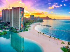 an aerial view of the beach and hotels at sunset