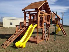 a wooden play set with a yellow slide