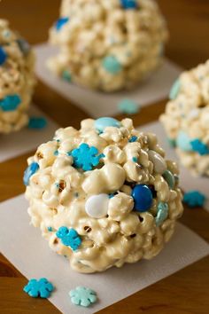 two cupcakes with white frosting and blue candies in them on a table