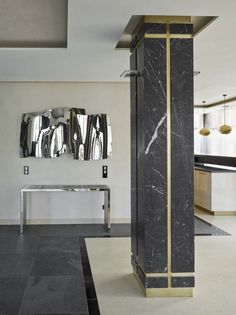 a black and gold room with mirrors on the wall, marble flooring and tables