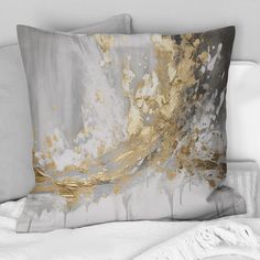 two pillows with gold and silver paint on them