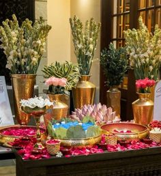 a table topped with lots of vases filled with flowers