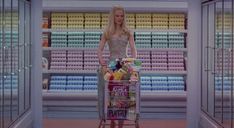 a woman pushing a shopping cart through a grocery store