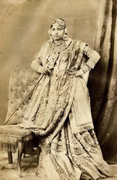 an old fashion photo of a woman sitting on a chair