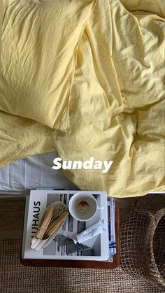 an image of a bed with yellow linens and coffee on the tray next to it